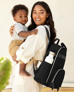 a woman holding a baby in her back pack