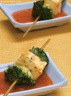 broccoli and cheese on skewers with sauce in small white dishes, ready to be eaten