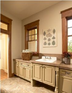 a large bathroom with double sinks and two windows