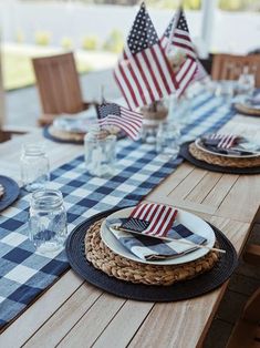 the table is set with blue and white checkered place mats, plates, and napkins