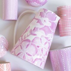 pink and white vases with polka dot designs on them next to other decorative items