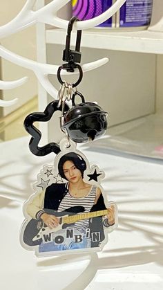 a keychain with an image of a woman holding a guitar on it's neck