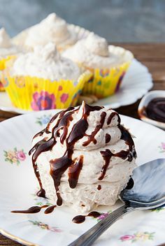 a piece of ice cream cake on a white plate with chocolate sauce drizzled over it