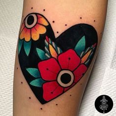 a heart shaped tattoo with flowers on it