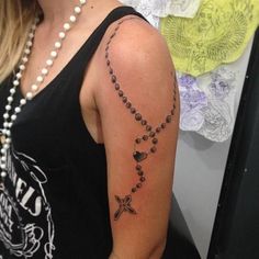 a woman with a rosary tattoo on her arm