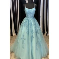 a light blue ball gown with flowers on the skirt and straps, sitting on a mannequin