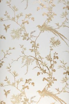 the wallpaper is white and has gold leaves on it