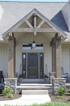 the front entrance to a home with stone pillars and columns on each side, along with an entry door