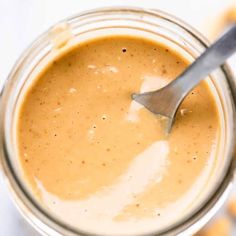 a spoon sticking out of a jar filled with peanut butter