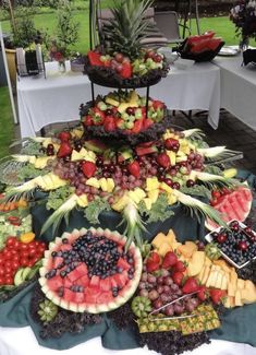 a table topped with lots of different types of fruits and veggies on top of each other