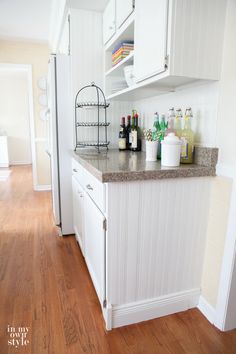 a kitchen with white cabinets and wooden floors