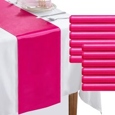 a table with pink napkins and plates on it