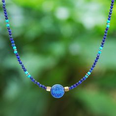 Thailand's Somluck Komolmith demonstrates her eye for fine detail and manual dexterity in this hand-beaded pendant necklace. A polished sphere of lapis lazuli commands your attention complemented by a beaded pattern featuring smaller lapis beads howlite beads and brass beads. On either side of the pendant golden hematite beads provide a visual anchor. The necklace features a spring ring clasp and extender chain of sterling silver. Bohemian Lapis Lazuli Beaded Necklaces As Gift, Bohemian Lapis Lazuli Beaded Necklaces For Gift, Bohemian Lapis Lazuli Beaded Necklace For Gift, Colorful Lapis Lazuli Bead Necklaces, Colorful Round Lapis Lazuli Bead Jewelry, Lapis Lazuli Crystal Necklace With Gemstone Beads, Lapis Lazuli Gemstone Beads Crystal Necklace, Colorful Lapis Lazuli Beaded Jewelry, Bohemian Lapis Lazuli Jewelry With Colorful Beads