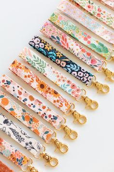 a row of colorful floral lanyards with gold handles