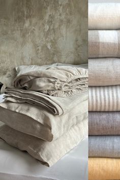 a stack of folded linens sitting on top of a bed next to a wall