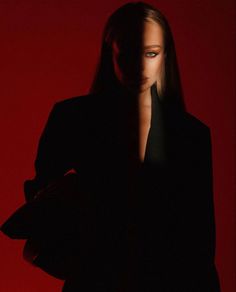 a woman in a black suit and red background