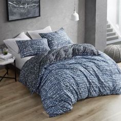 a bed with blue and white comforters in a room