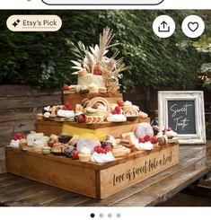 a wooden table topped with three tiered trays filled with cakes and pastries