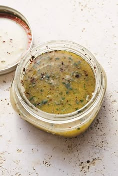 two jars filled with food sitting on top of a white counter next to each other