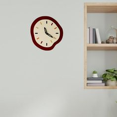 a clock is hanging on the wall next to a shelf with books and other items