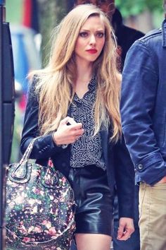 a woman walking down the street carrying a purse