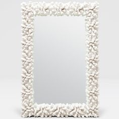 a white square mirror sitting on top of a table