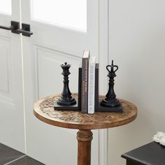 two bookends are sitting on a small table in front of a white door