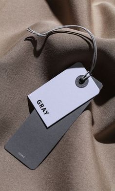 a tag that says gray on top of a brown cloth with a black and white tag