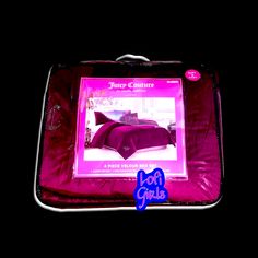 a pink suitcase with an advertisement on the front and back side in purple light, sitting against a black background