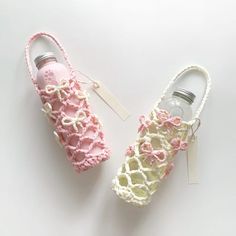 two crocheted shoes with tags attached to them sitting next to each other on a white surface