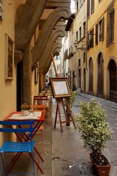 an alleyway with tables and chairs lined up