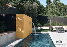 a backyard with a small pool and lounge chairs next to the water feature, surrounded by trees