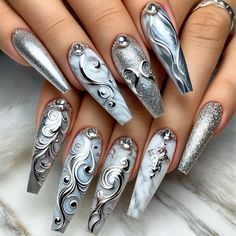 This stunning set of long coffin-shaped nails features an intricate silver-themed design. The nails showcase elegant swirling patterns in metallic silver with highlights of light and dark tones, creating a sophisticated and dynamic look. Embellished with silver rhinestones and glitter accents. #nails #nailsofinstagram#pressonnails #nailstagram #nailswag #nailsfordays #nailsonfleek Expensive Nails Design, Silver Nails With Rhinestones, Silver Gem Nails, Silver Square Nails, Hip Hop Nails, Silver And White Nails, Silver Chrome Nails, Nye Nails, Silver Nail Designs