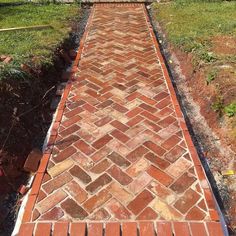 a brick walkway in the middle of a yard