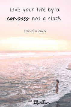 a woman standing in the ocean with a quote about life by a compass not a clock