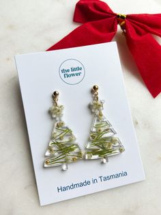 The Christmas Tree Earrings are not only incredibly adorable BUT they're also made with REAL CHRISTMAS TREE!  Dainty, lightweight Christmas Tree-shaped pendants made with beautiful green Christmas tree needles and white Rice Flowers finished in 14k gold plating or silver plating 🎄✨ Your Christmas Day jewellery is complete!!  - Handmade in Tasmania - Made to order - Free shipping over $60 - Resin Flower Jewellery  - Perfect unique gift for Christmas  Avoid wear in water and store out of direct sunlight.  Follow our Instagram for behind the scenes of The Little Flower Handmade @littleflowerearrings Green Earrings New Year Gift, Green Earrings For New Year Gift, Green Earrings Gift For New Year, Resin Christmas Earrings, Christmas Resin Earrings, Christmas Resin, Christmas Jewellery, Christmas Craft Fair, Real Christmas