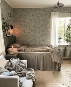 a bedroom with a bed, couch and window