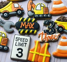 decorated cookies with construction theme are arranged on a table