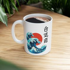 there is a coffee cup that has been decorated with the great wave and japanese characters