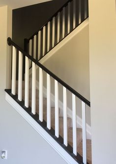 a staircase with white railing and black baluster