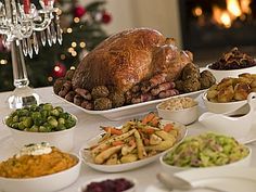 a large turkey sitting on top of a table next to bowls of vegetables and other foods