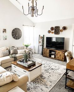 a living room filled with furniture and a flat screen tv on top of a wooden table