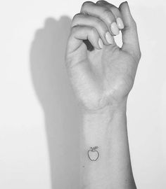 a small apple tattoo on the wrist