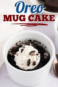 oreo mug cake in a white bowl with whipped cream and chocolate cookies on the side