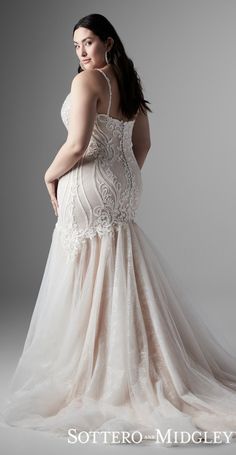 a woman in a wedding dress posing for the camera with her hand on her hip