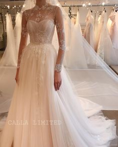 a woman standing in front of wedding gowns