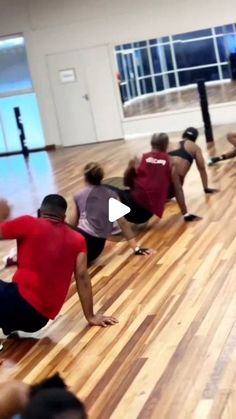 a group of people doing stretching exercises in a gym