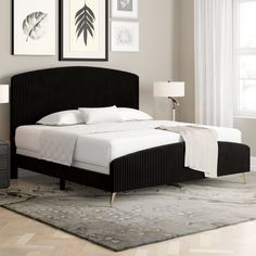 a black bed with white sheets and pillows