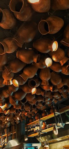 many brown pots are hanging from the ceiling