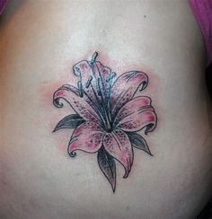 a woman's stomach with a pink flower tattoo on her belly and the side